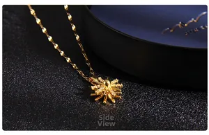 Side view of golden windmill necklace pendant with cubic zirconia on textured background