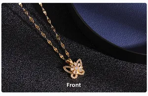 Front view detail of a gold butterfly necklace with micro-set zircon on a dark background
