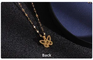 Detailed back view of gold butterfly pendant with hollow wing pattern on black leather