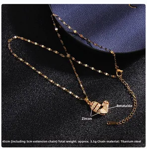 Macro detail of rotating heart pendant with micro-paved zircons on gold titanium steel chain
