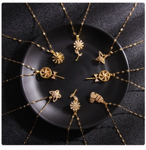 Detailed view of multiple gold-plated necklaces with zircon pendants on black tray