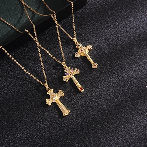 Three gold plated cross necklaces with micro-pave zircons on black leather texture