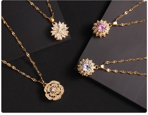 Close-up of rotating gold clover pendants with colorful zircons and rose flower details