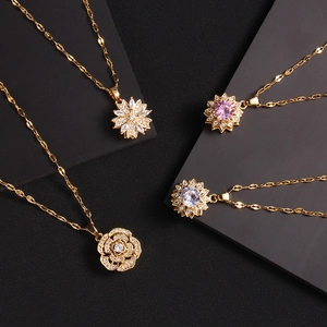 Golden clover necklaces with zircon rotating pendants on dark geometric background