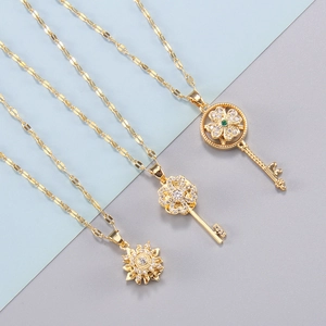 Gold rotating sun and key pendant necklace with zircon stones on a dual-tone background
