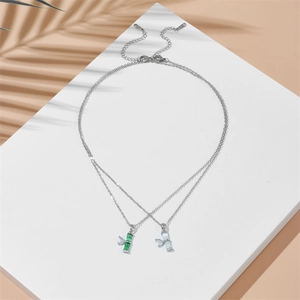 Bamboo style stainless steel necklaces with green stones and palm leaf shadows