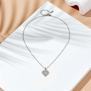 Collier avec pendentif cœur en acier inoxydable et oxydes de zirconium sur socle blanc