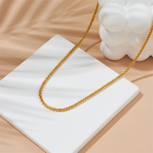 Minimalistische gouden titanium stalen slangenketting op een modern wit blok display