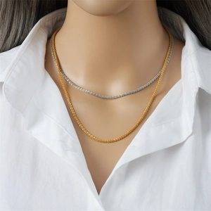 Minimalistische dubbellaagse goud en zilver titanium stalen ketting op wit overhemd