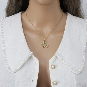 Elegante collana in titanio dorato con ciondolo a farfalla colorata e perle su pizzo bianco