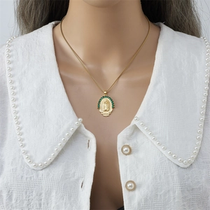 Collar dorado de la Virgen María con colgante ovalado y gemas verdes en camisa de encaje