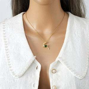 Golden reindeer necklace with emerald green gemstone and white crystal accents