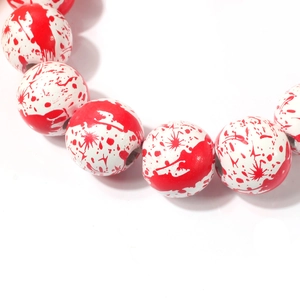 Detail of white beads with realistic red blood splatter for Halloween necklace jewelry
