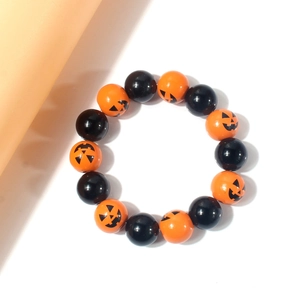 Halloween beaded bracelet featuring orange pumpkin face charms and glossy black resin beads