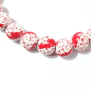Close-up of Halloween necklace beads with realistic red blood splatter on white base
