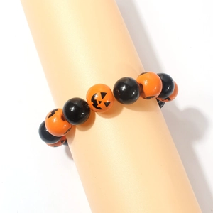 Detailed view of Halloween beaded bracelet featuring orange pumpkin face beads and black accents