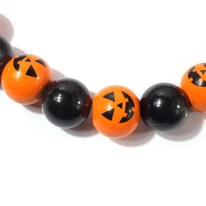Close-up of orange and black beads featuring festive Jack-o'-lantern pumpkin patterns