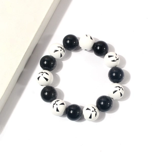Minimalistisches Halloween Perlenarmband mit schwarz-weißen Jack-O-Lantern Kürbismustern