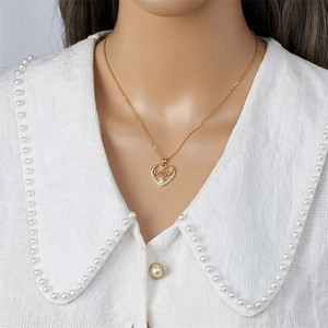 Collier cœur doré avec gravure MUM et détails en zircon sur mannequin en dentelle