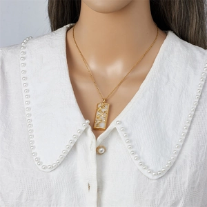Collana vintage placcata oro con drago e pietra bianca su colletto di camicia di perle