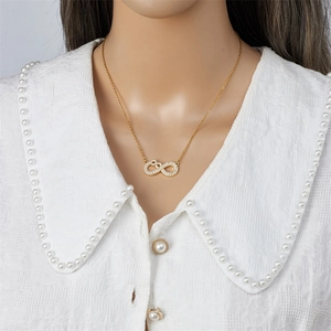 Collar infinito dorado con circonitas sobre un cuello de encaje blanco