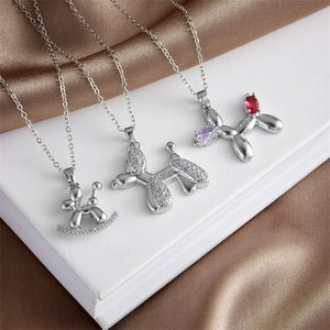 Three elegant silver balloon dog necklaces with sparkling cubic zirconia on brown silk