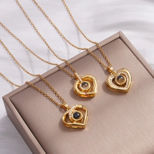 Golden heart projection necklace with micro-carved I Love You stone on satin background