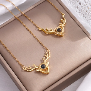 Golden reindeer antler projection necklace with heart design and tiny sparkling crystals
