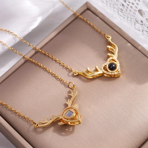Golden reindeer heart projection necklace with polished crystals on elegant jewelry box
