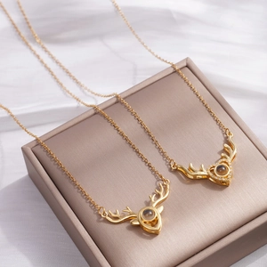 Golden reindeer antler projection necklaces with heart pendant on jewelry box