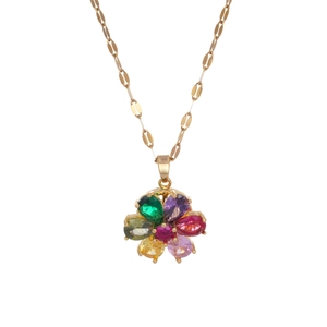 Pendentif fleur rotatif doré avec zircons colorés sur collier sur fond blanc pur