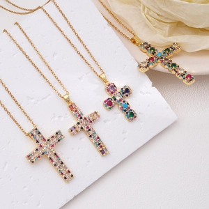 Minimalistische gouden titanium kruis ketting met gekleurde zirkoonstenen op achtergrond