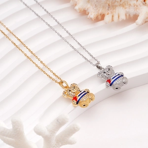 Gold and silver sailor bear necklaces with cubic zirconia and enamel on a shell background