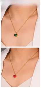 Close-up of heart-shaped zircon pendants in dark green and red on golden chains