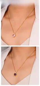 Close-up of heart-shaped gemstone necklaces in pink and purple on a gold chain