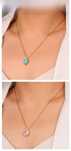Detailed view of heart-shaped gemstone pendant necklaces in turquoise and clear on gold chain