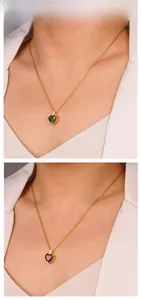Close-up of heart-shaped gemstone necklace with gold chain and cubic zirconia accents