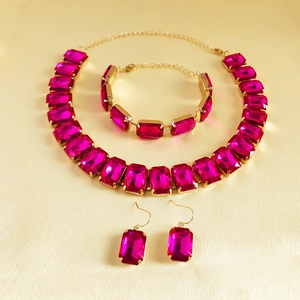Detail of rose pink rhinestone jewelry set including necklace, bracelet and earrings