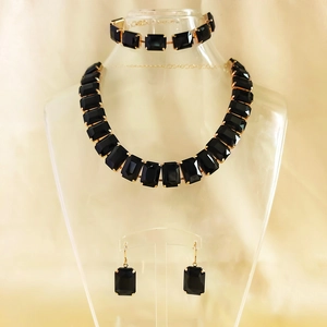 Dramatic gold necklace set with black rectangular stones and matching earrings and bracelet