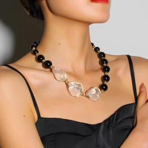 Dettaglio di grosse perle nere e cristalli trasparenti su una collana moda