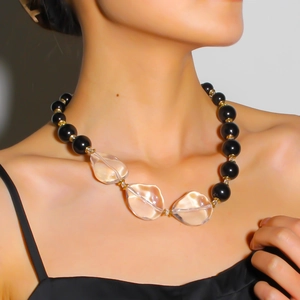 Dettaglio della collana di perle nere con cristalli trasparenti e distanziali in metallo dorato