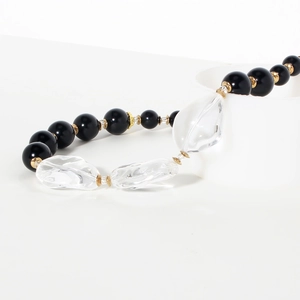Dettaglio collana di perle nere con perle di cristallo trasparente e distanziatori oro