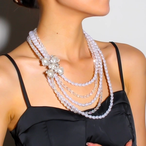 Gros plan d'un collier de perles multicouche avec fermoir floral serti de diamants