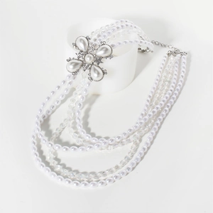 Détail d'un collier de perles multicouche avec pendentif fleur en strass brillant