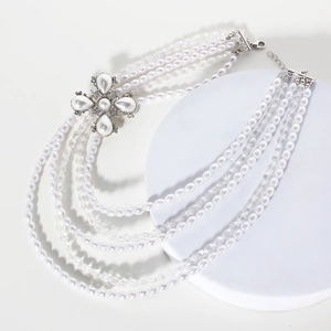 Détail d'un collier de perles à cinq rangs avec pendentif fleur en cristal scintillant
