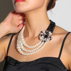 Detail of vintage multilayer necklace with pearls, black beads, and floral accents