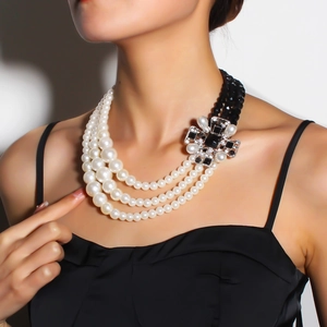 Detail of multi-layer pearl necklace with vintage rhinestone cross flower pendant clasp
