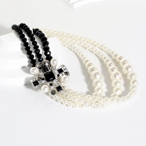 Retro multilayered necklace with pearls, black beads, and a crystal cross pendant