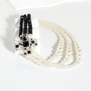 Detail view of a vintage multi-layer necklace with black beads and faux pearls