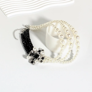 Detail of multi-layer vintage necklace with pearls, black beads and crystal centerpiece